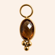 Ma boutique Ambre interchangeable earring charm with a faceted oval amber stone and gold stainless steel details.