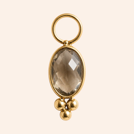 Ma boutique Ambre interchangeable earring charm with an oval amber-toned stone and gold stainless steel accents.