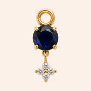 Ma boutique Céleste gold interchangeable earring charm with a round dark blue stone and a small crystal star detail.