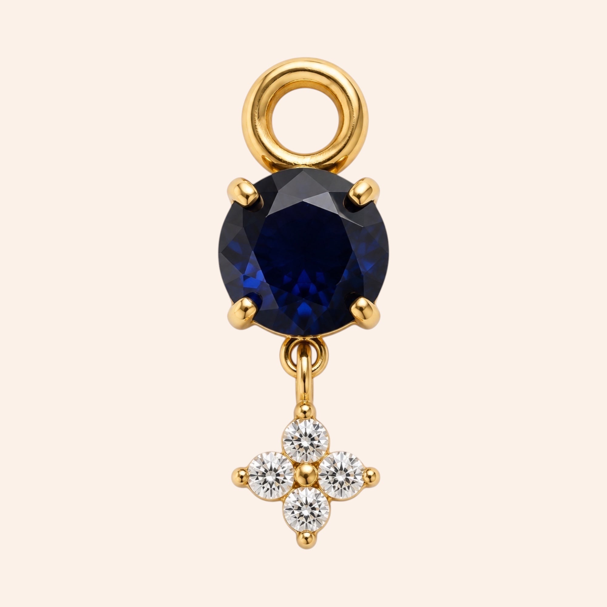 Ma boutique Céleste gold interchangeable earring charm with a round dark blue stone and a small crystal star detail.