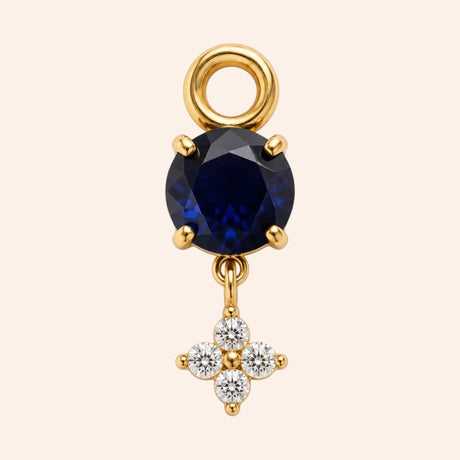 Ma boutique Céleste gold interchangeable earring charm with a round dark blue stone and a small crystal star detail.