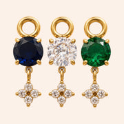 Ma boutique Céleste interchangeable earring charms in gold with blue, clear, and green round stones and star accents.