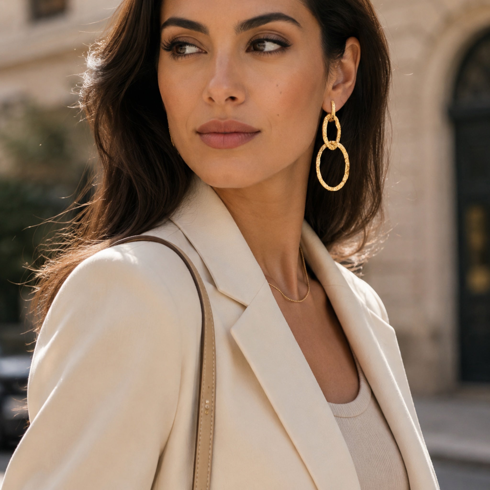 Ma boutique Eclipse gold interchangeable earring charm featuring two interlocking textured rings worn by a woman