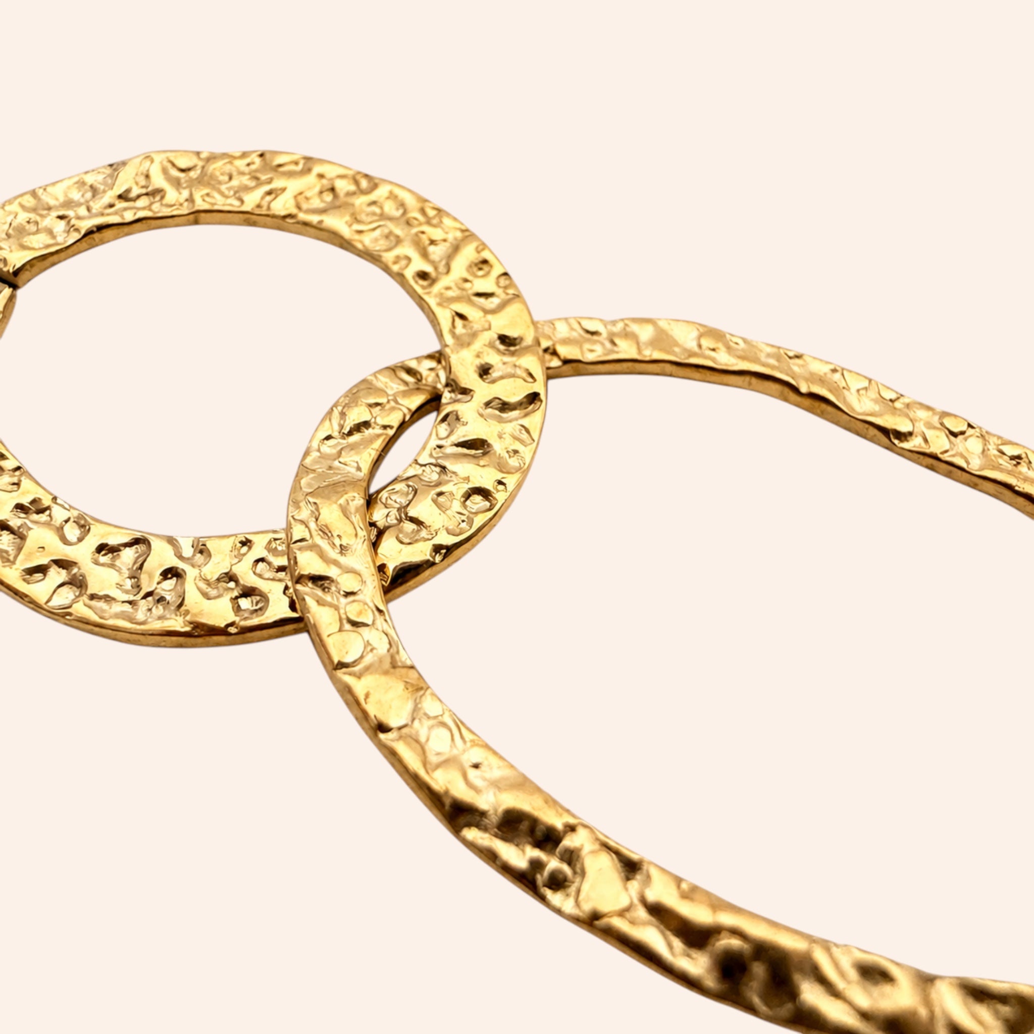 Ma boutique Éclipse gold interchangeable earring charm featuring two interlocking rings with a textured finish.