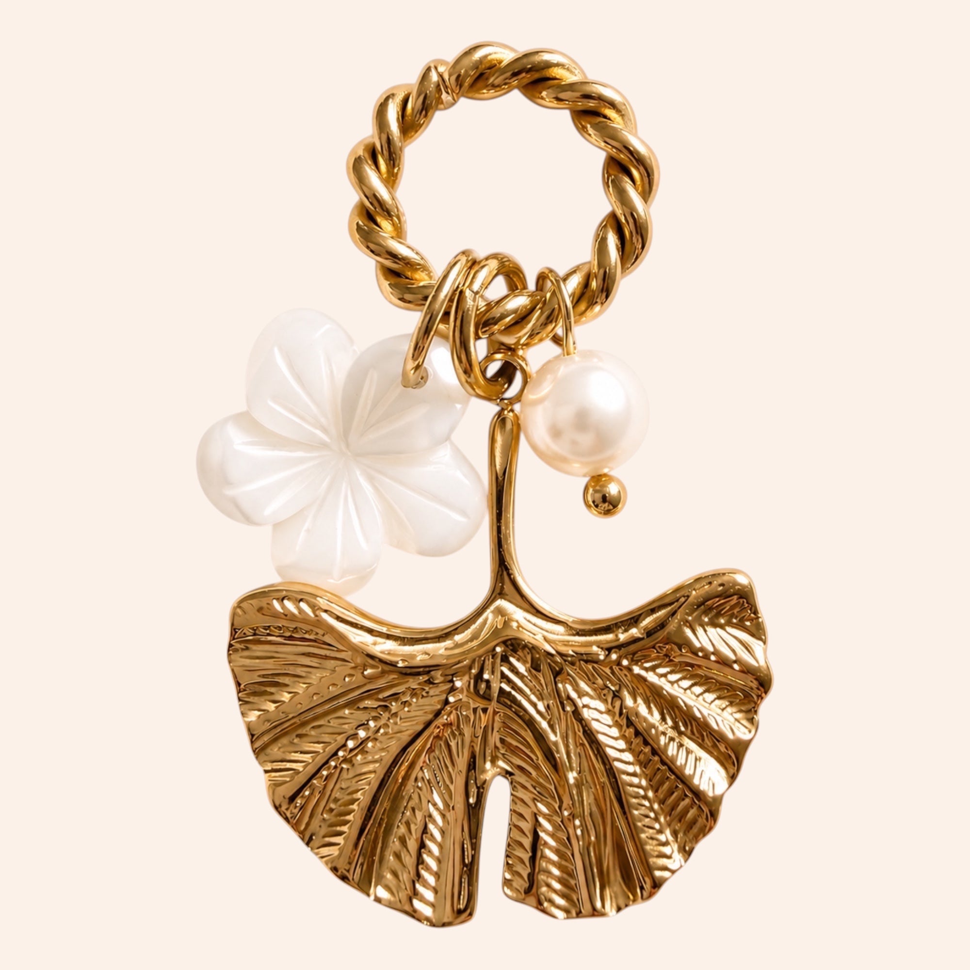 Ma boutique Ginkgo interchangeable gold leaf charm with white flower and pearl accents on a twisted ring