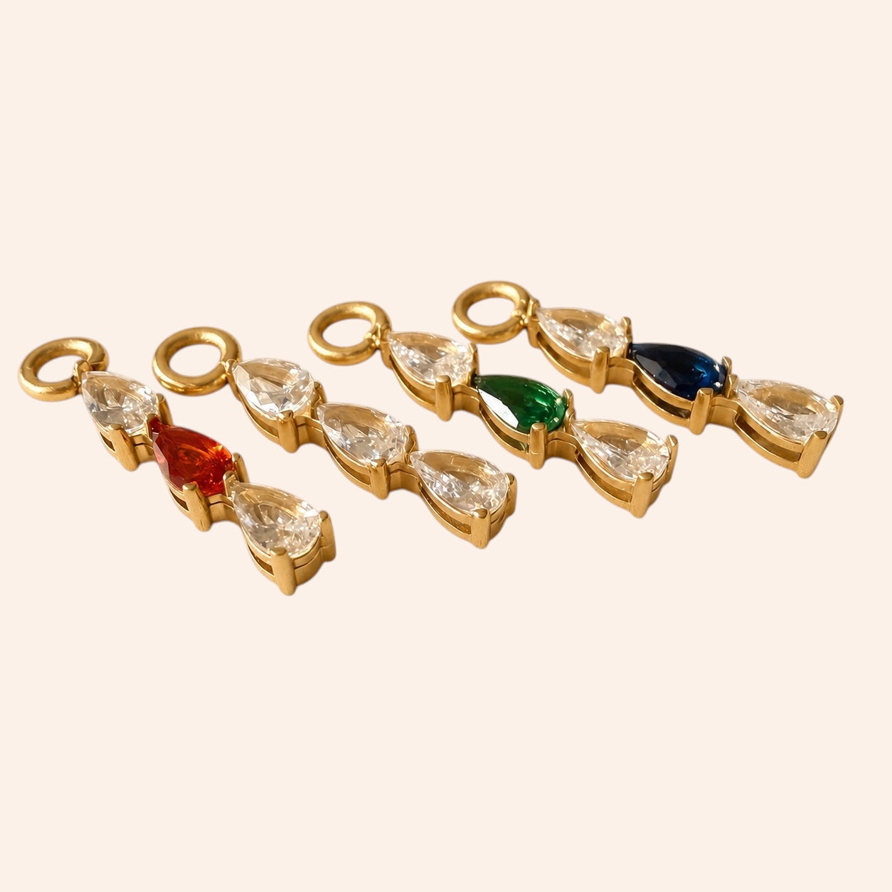 Ma boutique Goutte interchangeable earring charms in gold-tone stainless steel with multi-colored teardrop stones.