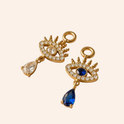 Ma boutique Nazar interchangeable gold earring charms featuring blue and clear crystal eye motifs with teardrop drops.