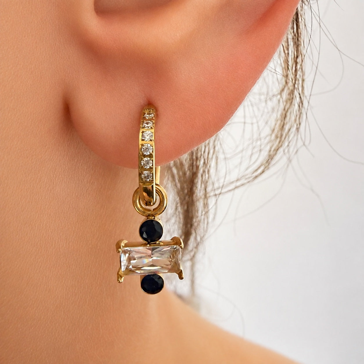 Ma boutique Regard interchangeable gold earring charm with a graphic eye motif and clear crystal on a hoop earring